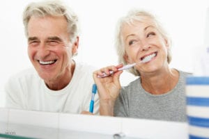 Elderly Couple Joyfully Brushing Their Teeth